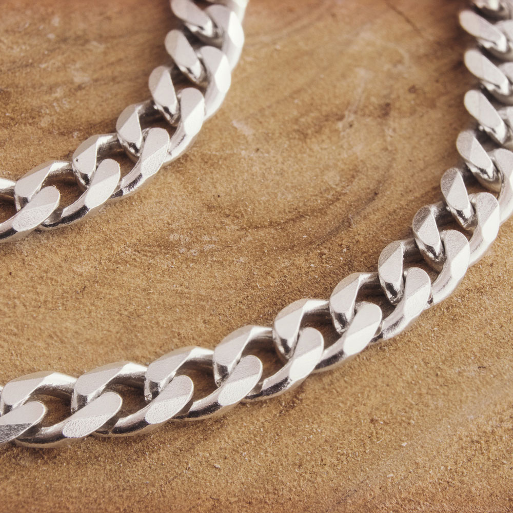 curb chain bracelet with a hook clasp made of sterling silver on a wooden background