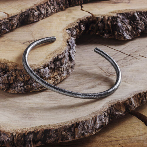 Thin Cuff Bracelet with a Frosted Finish in Dark Silver on a wooden background