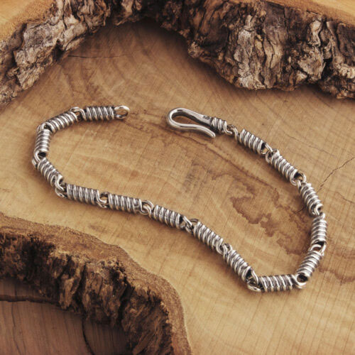 Silver Spring Coil Bracelet with a Spiral Chain on a Wooden Backgroujnd