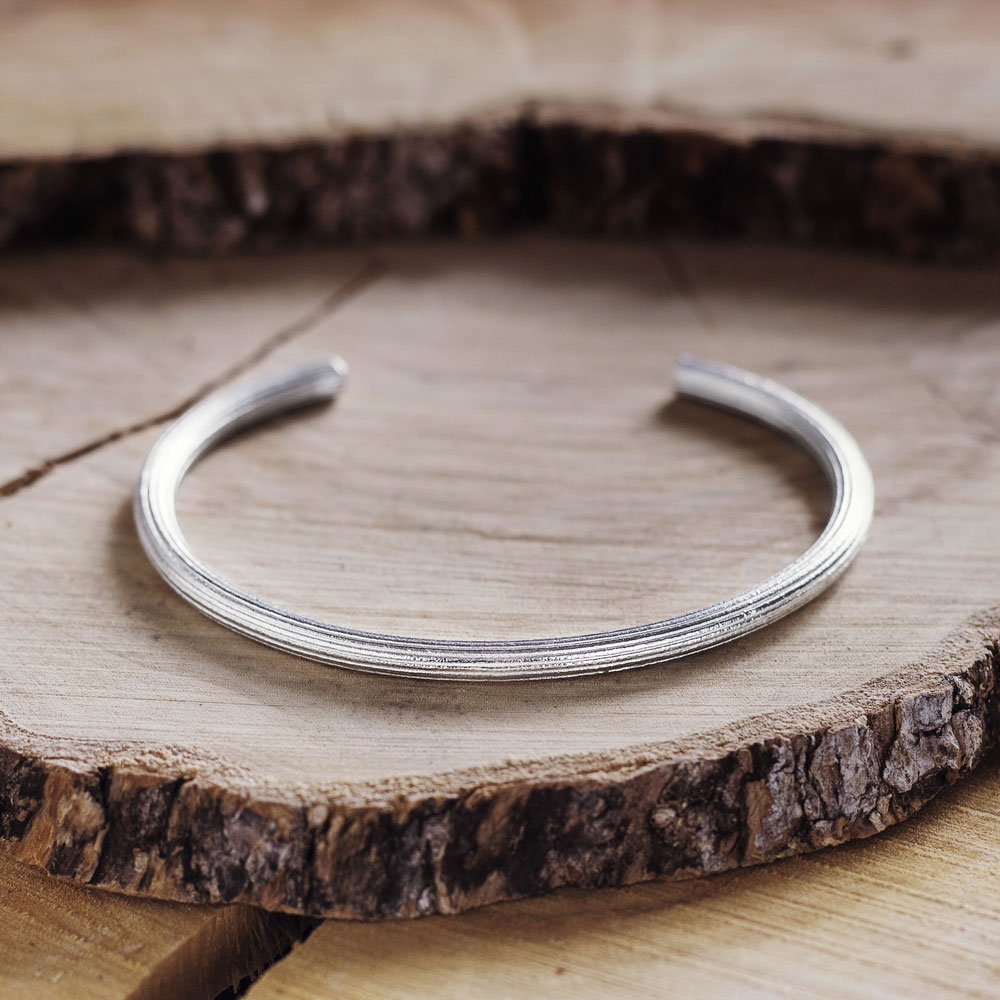 Ribbed Cuff Bracelet in Sold Sterling Silver on a wooden background