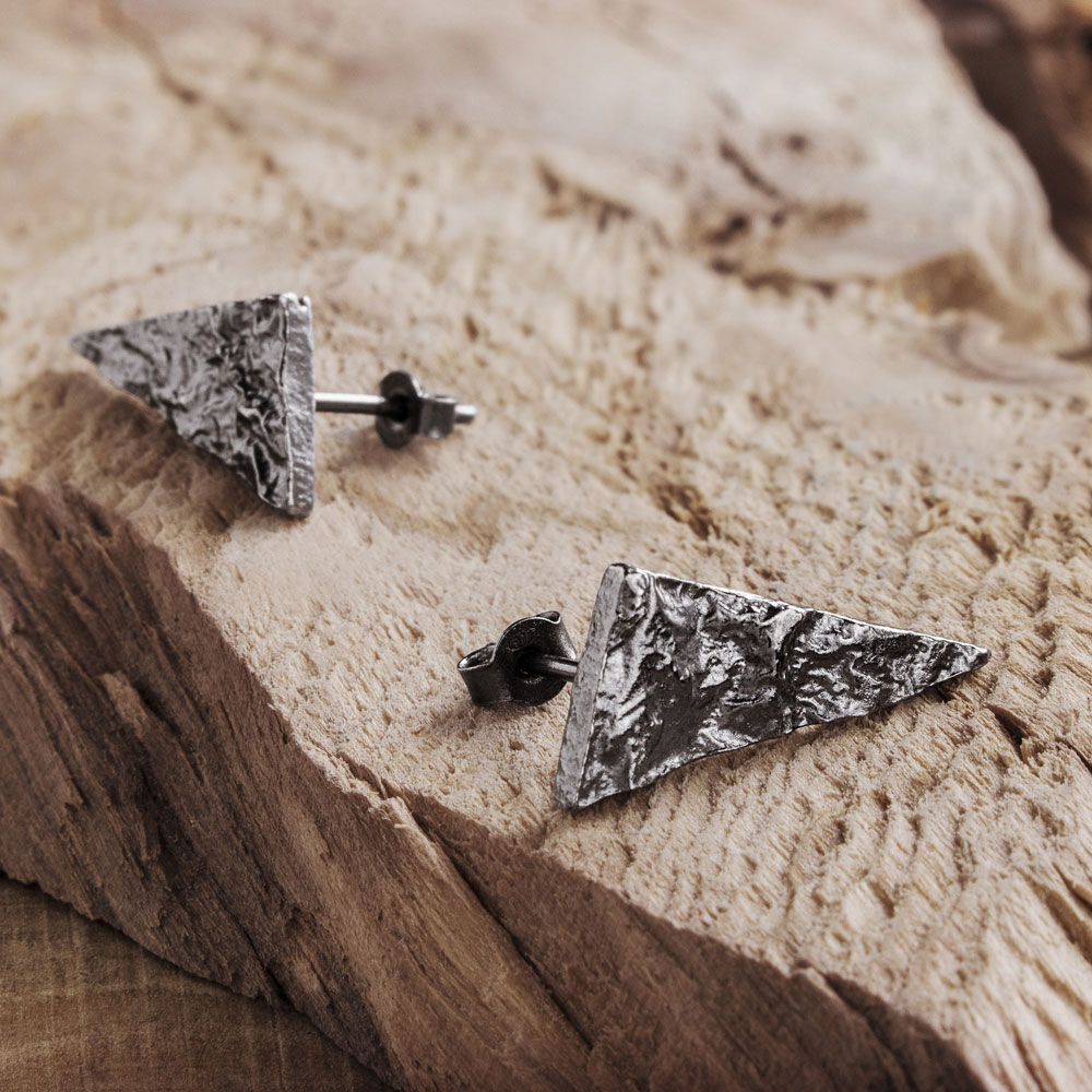 Silver Triangle Earrings with an Oxidized Textured Surface on a Wooden Surface