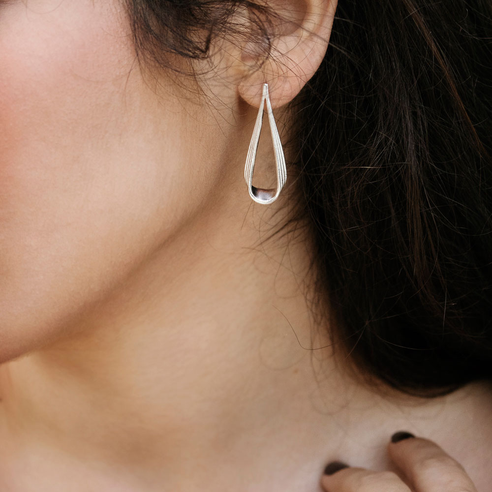 Long Drop Shape Earrings Worn By A Woman