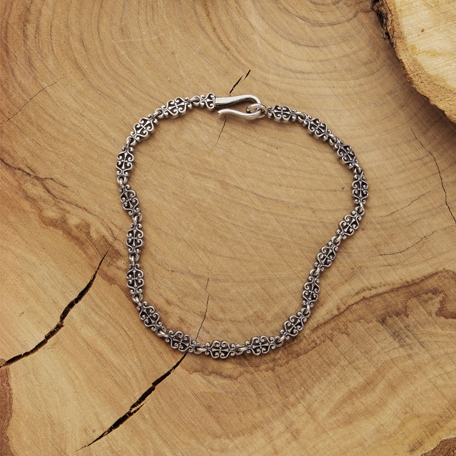 Silver Chain Bracelet with a Floral Design in wooden backgroundSilver Chain Bracelet with a Floral Design on Wooden Background