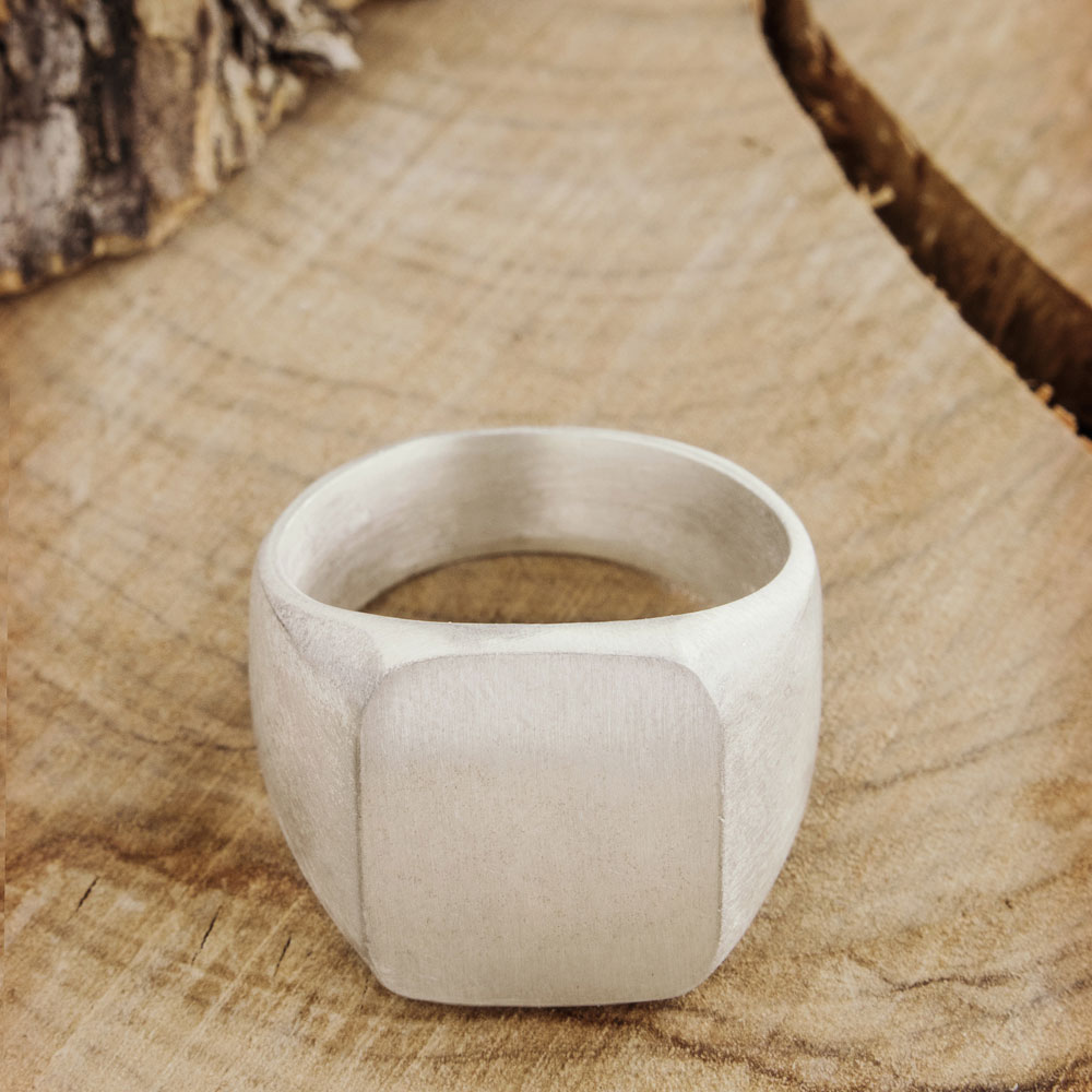 Engravable Signet Ring (Chevalier) in Sterling Silver on a wooden background
