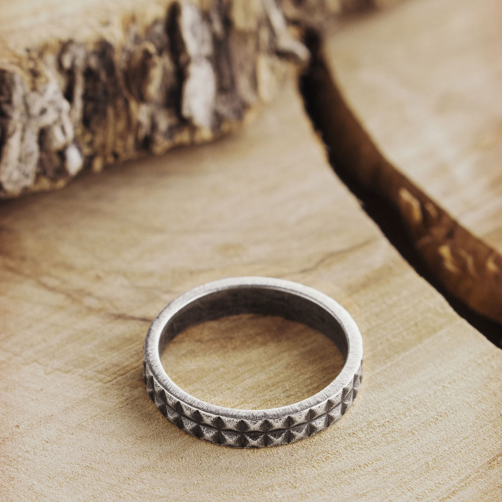 oxidized silver Pyramid Shaped Ring on a wooden background