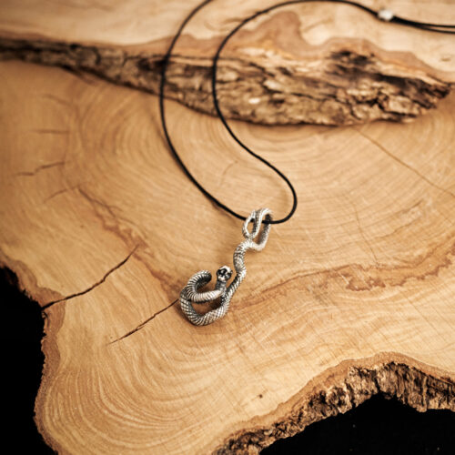Snake Pendant Necklace in Oxidized Solid Silver displayed on a log