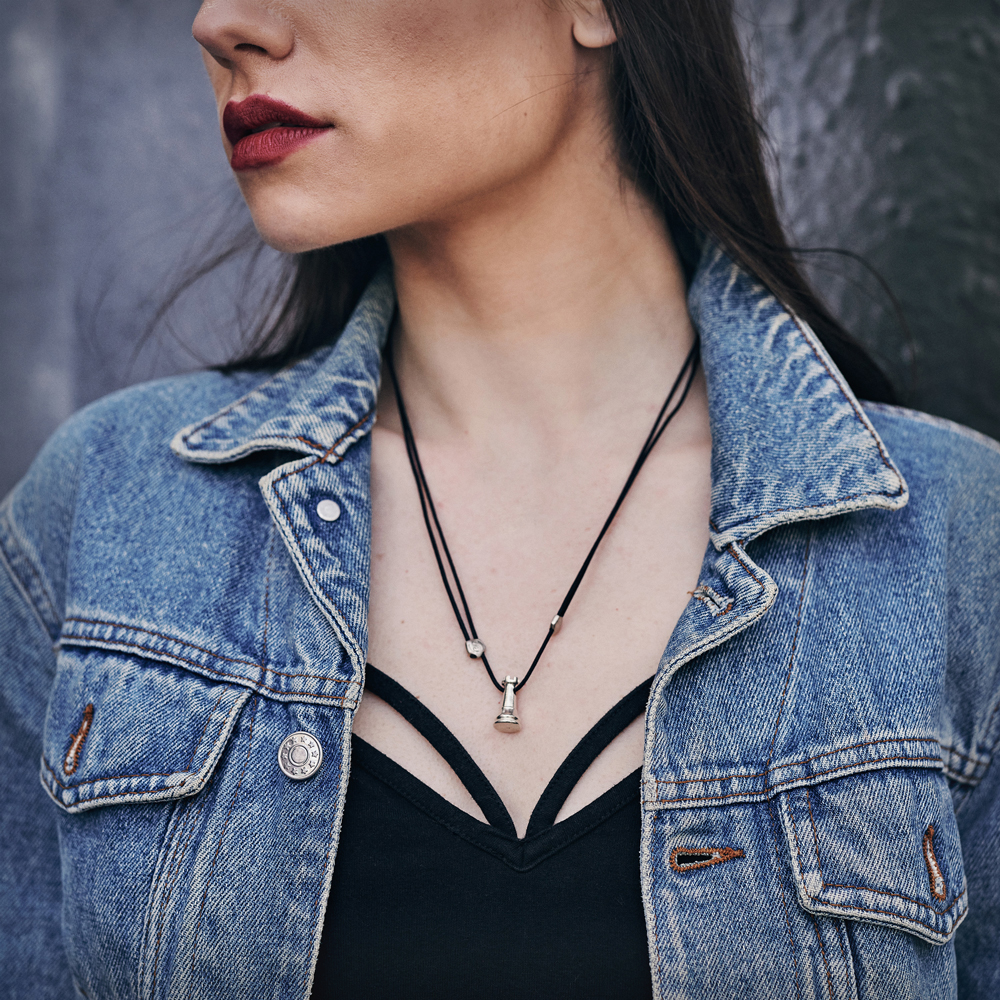 A White Rook Chess Piece Necklace in Solid Sterling Silver with a black word worn by a female model.